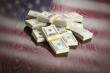 Image showing Thousands of Dollars with Reflection of American Flag on Table