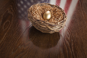 Image showing Golden Egg in Nest with American Flag Reflection on Table