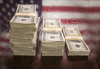 Image showing Thousands of Dollars with Reflection of American Flag on Table