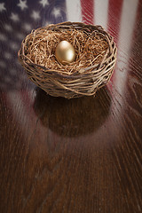 Image showing Golden Egg in Nest with American Flag Reflection on Table