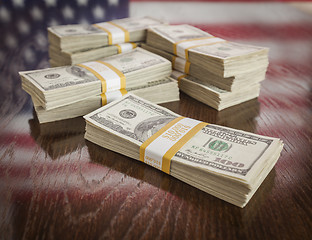 Image showing Thousands of Dollars with Reflection of American Flag on Table
