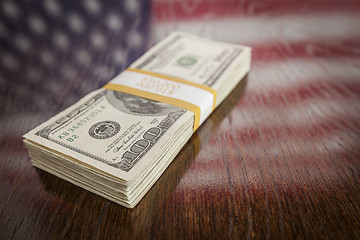 Image showing Thousands of Dollars with Reflection of American Flag on Table