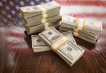 Image showing Thousands of Dollars with Reflection of American Flag on Table
