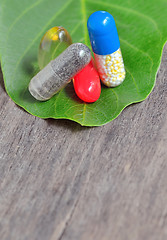 Image showing vitamins, tablets and pills on green leaf