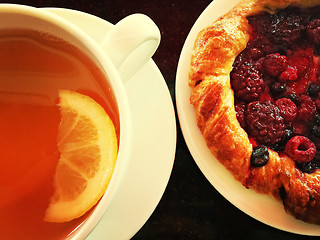 Image showing Cup of tea with raspberry pastry