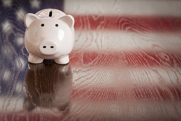 Image showing Piggy Bank with an American Flag Reflection on Table