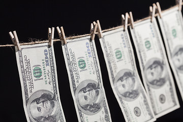 Image showing Hundred Dollar Bills Hanging From Clothesline on Dark Background