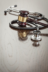 Image showing Gavel and Stethoscope on Reflective Table