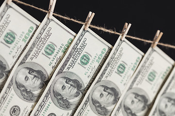 Image showing Hundred Dollar Bills Hanging From Clothesline on Dark Background