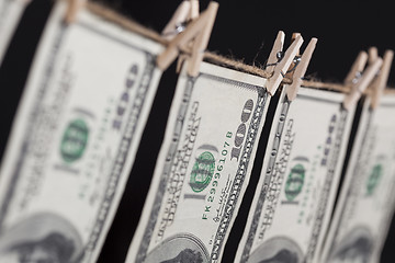 Image showing Hundred Dollar Bills Hanging From Clothesline on Dark Background