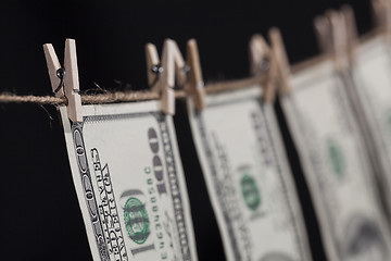 Image showing Hundred Dollar Bills Hanging From Clothesline on Dark Background