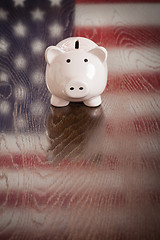 Image showing Piggy Bank with an American Flag Reflection on Table