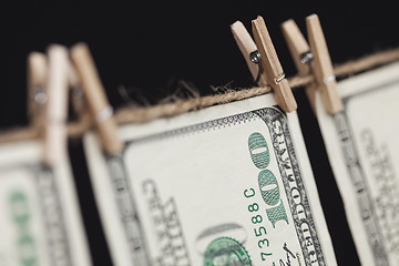 Image showing Hundred Dollar Bills Hanging From Clothesline on Dark Background