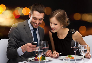 Image showing smiling couple eating main course at restaurant