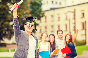 Image showing smiling teenage boy in corner-cap with diploma