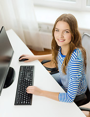 Image showing dreaming teenage girl with computer at home