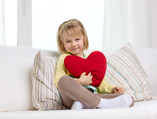 Image showing smiling little girl with red heart at home