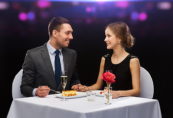 Image showing smiling couple eating dessert at restaurant