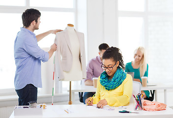 Image showing smiling fashion designers working in office