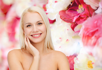 Image showing smiling young woman touching her face skin