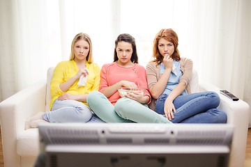 Image showing three sad teenage girl watching tv at home