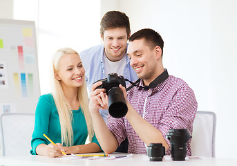 Image showing smiling team with photocamera working in office