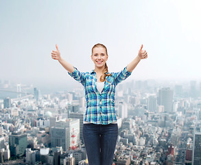 Image showing smiling girl in casual clothes showing thumbs up