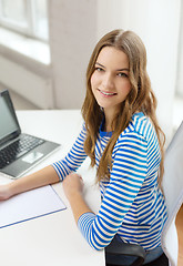 Image showing smiling teenage girl laptop computer and notebook