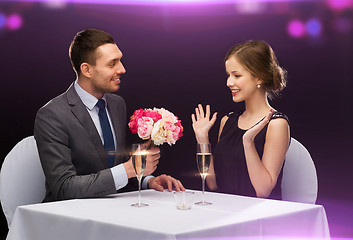 Image showing smiling man giving flower bouquet to woman