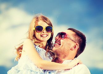 Image showing happy father and child in sunglasses over blue sky