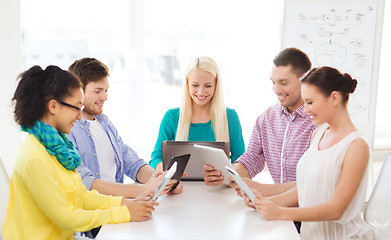 Image showing smiling team with table pc and laptop in office