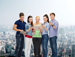 Image showing smiling students using smartphones and tablet pc