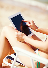 Image showing girl looking at tablet pc on the beach