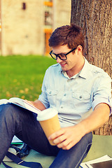 Image showing teenager reading book with take away coffee