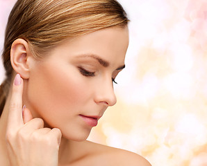 Image showing calm woman touching her ear