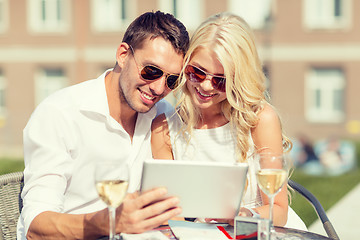 Image showing couple looking at tablet pc in cafe