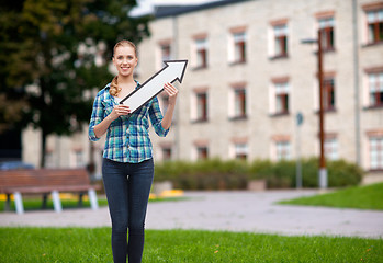 Image showing smiling young woman with arrow poiting up