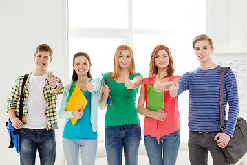 Image showing smiling students with bags and folders at school