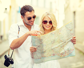 Image showing smiling couple in sunglasses with map in the city