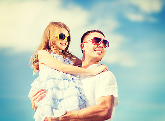 Image showing happy father and child in sunglasses over blue sky