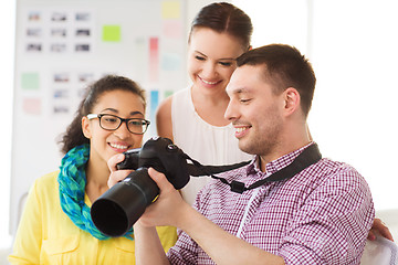 Image showing smiling team with photocamera working in office