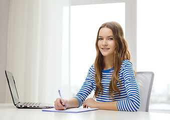 Image showing smiling teenage girl laptop computer and notebook