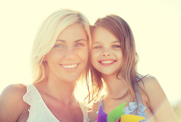 Image showing happy mother and child girl with pinwheel toy