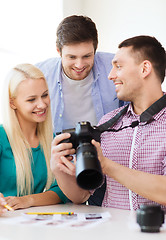 Image showing smiling team with photocamera working in office