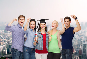 Image showing group of standing smiling students with diploma