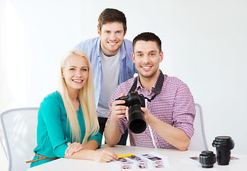 Image showing smiling team with photocamera working in office