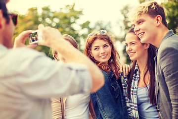 Image showing teenagers taking photo with digital camera outside
