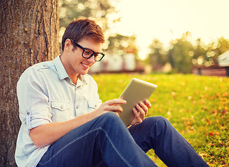 Image showing smiling male student in eyeglasses with tablet pc