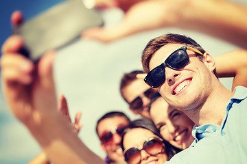 Image showing group of friends taking picture with smartphone