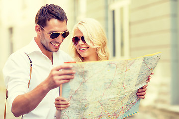 Image showing smiling couple in sunglasses with map in the city